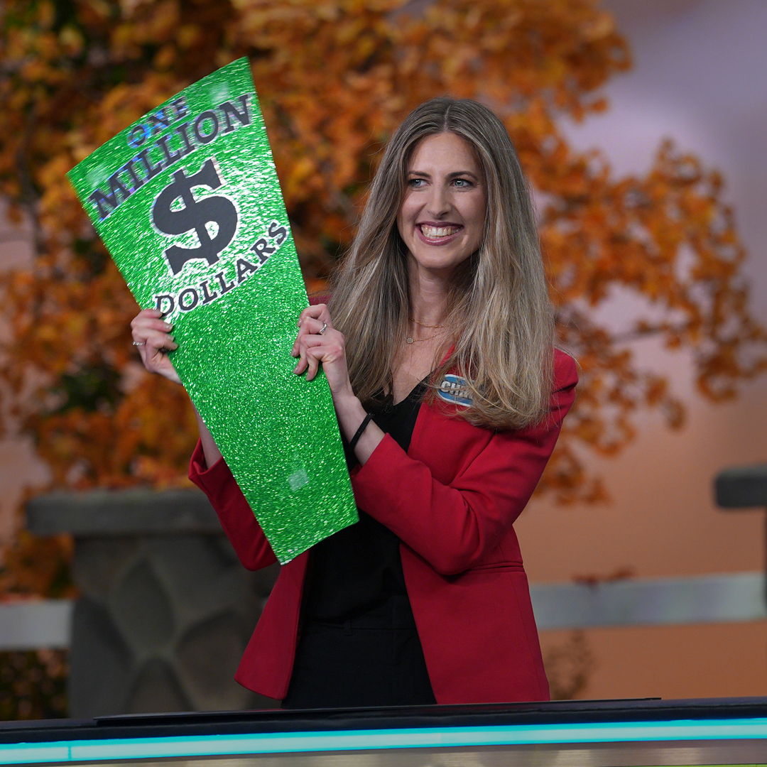 Christina holding the million dollar wedge on the set of wheel.  